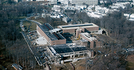 Uniformed Services University of the Health Sciences (USU) construction progress, nearing completion, March 1979. The National Naval Medical  Center is seen in the background.